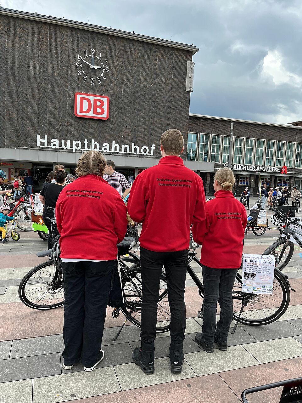 JRK Mitarbeiter*innen vor dem Hbf Aufnahme drei Jugendrotkreuz Mitglieder