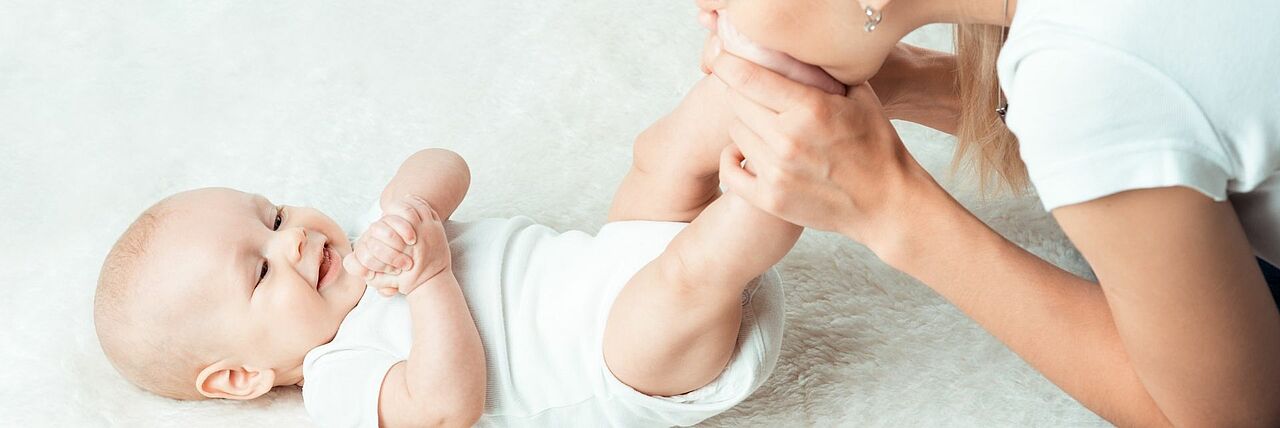 Baby wird von seiner Mutter geküsst